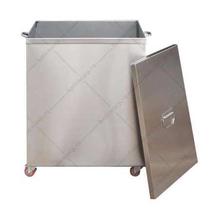 Thùng rác inox vuông có bốn bánh xe, nắp đậy dựng nghiêng bên cạnh