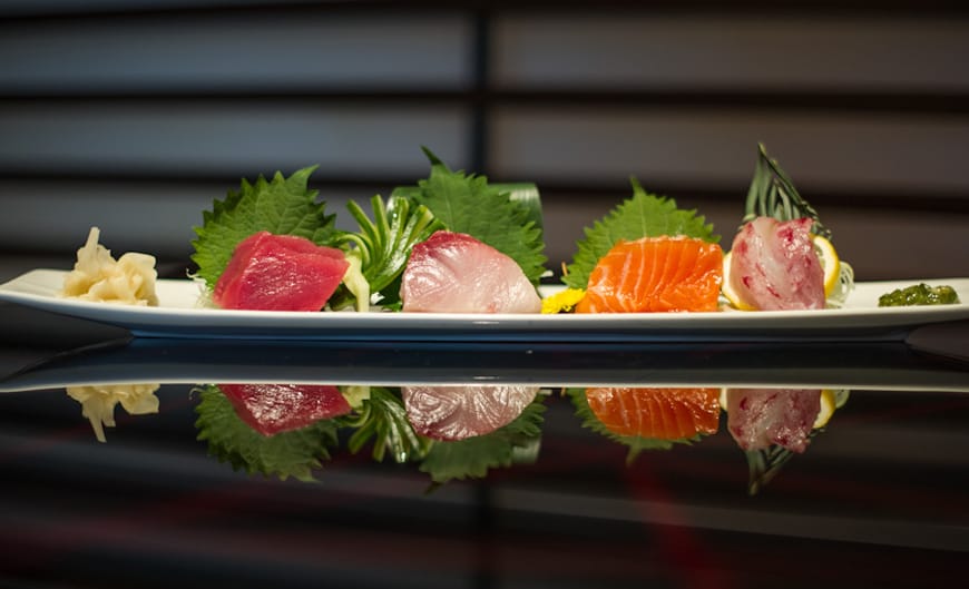 Đĩa sashimi cá hồi, cá ngừ và cá trắng bày trên lá tía tô