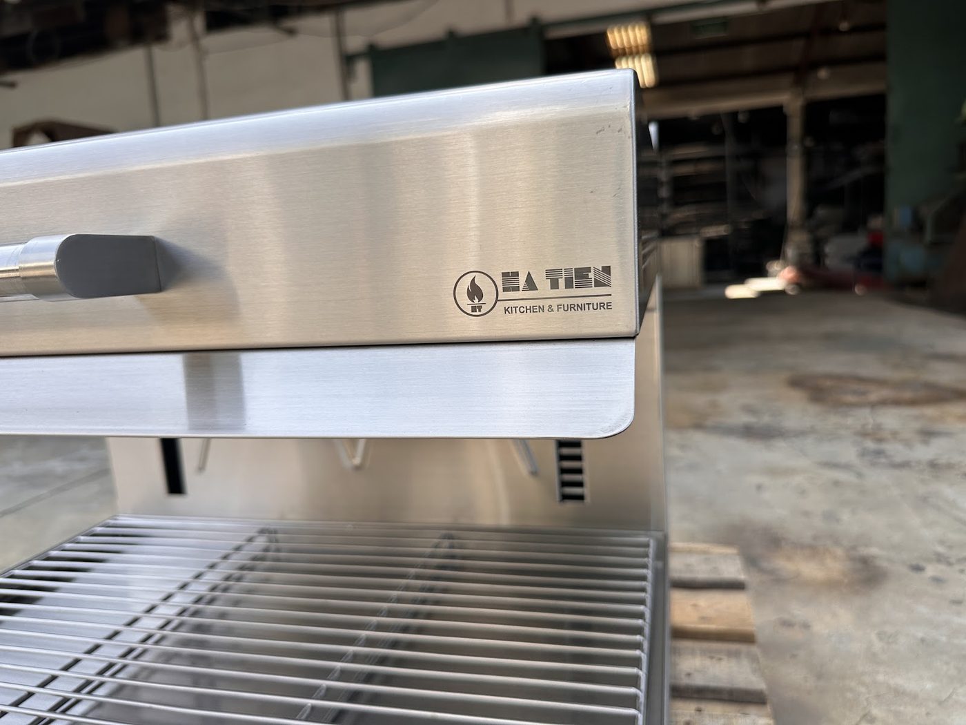 Logo Hà Tiên Kitchen & Furniture khắc laser trên thân lò salamander tại xưởng sản xuất