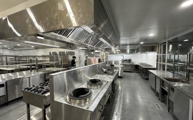 Tuyến bếp xào wok công nghiệp inox Hà Tiên với bàn lạnh và kệ inox trong khu bếp nhà hàng mới