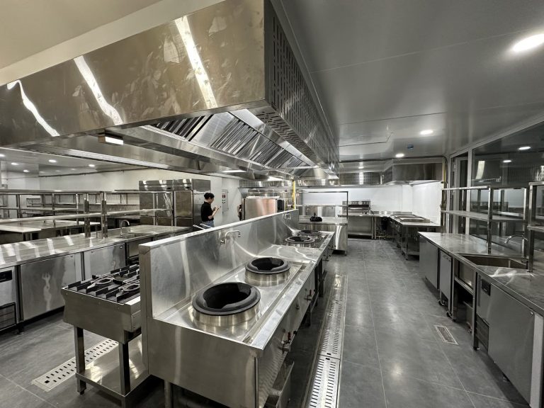 Tuyến bếp xào wok công nghiệp inox Hà Tiên với bàn lạnh và kệ inox trong khu bếp nhà hàng mới