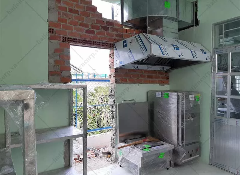Tủ nấu cơm công nghiệp và bếp hầm được đặt dưới chụp hút khói