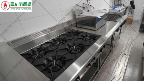 Bếp âu 6 họng gang đang lắp đặt tại công trình, bên cạnh là rãnh thoát nước sàn