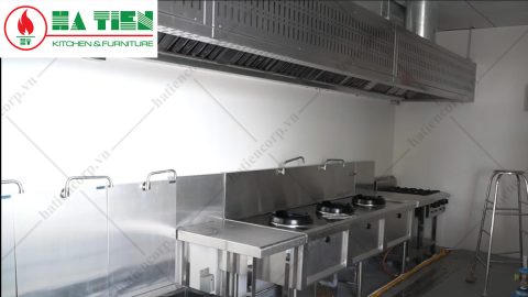 Dãy bếp âu và bếp á đã lắp dưới chụp hút inox tại công trình, có vòi nước gắn tường