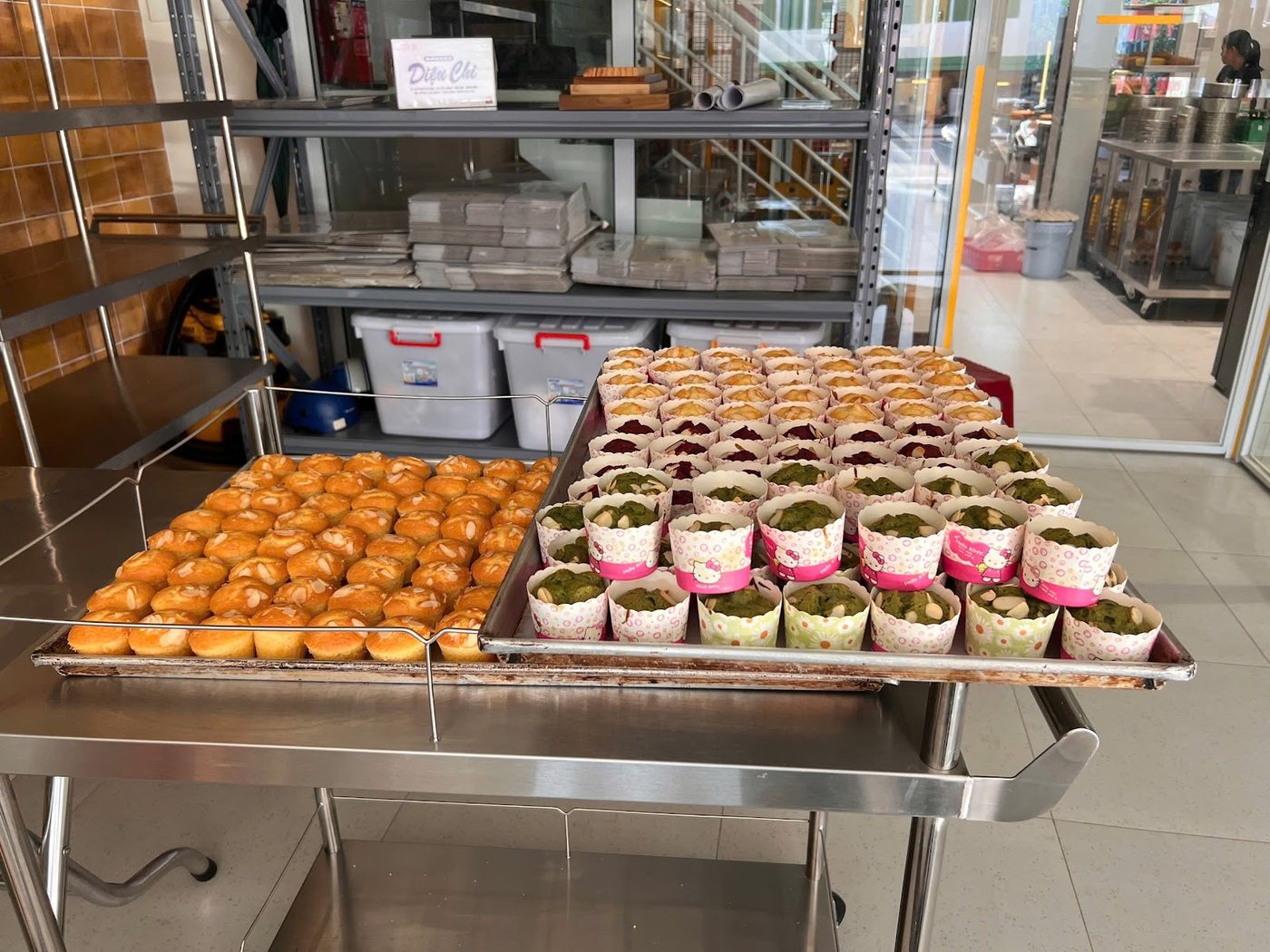 Xe đẩy inox chở hai khay bánh muffin mới ra lò trong xưởng bánh do Hà Tiên cung cấp thiết bị