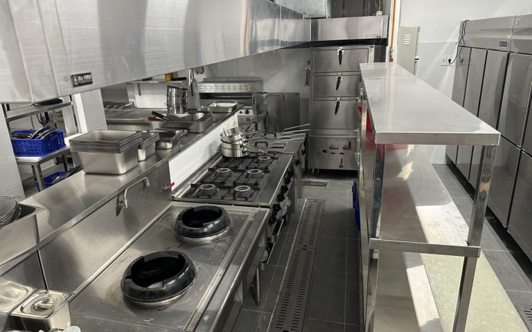 Dãy bếp xào wok đặt đối diện bếp Âu 4 họng và tủ hấp trong khu bếp nhà hàng do Hà Tiên lắp đặt