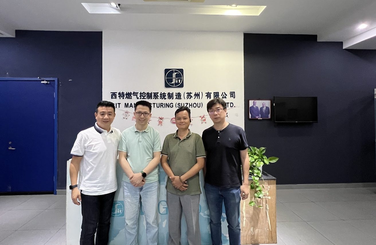 Đoàn Hà Tiên cùng đại diện SIT trước logo hãng tại nhà máy Tô Châu