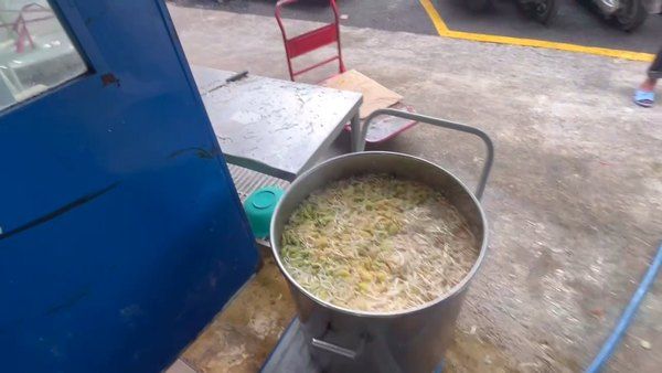 Nồi canh đã nấu chín đặt trên xe đẩy tại khu ngoài trời của bếp ăn công nghiệp