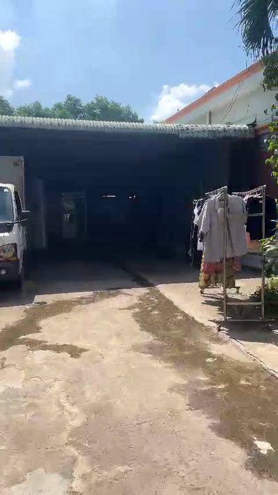 Lối vào khu bếp công nghiệp 2.000 suất nhìn từ sân ngoài, xe và người đi chung một vùng chuyển tiếp