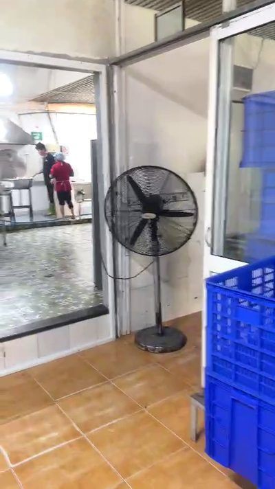 Quạt đứng đặt sát tường trong bếp công nghiệp mái tôn thấp, dùng thay hệ thống hút nhiệt