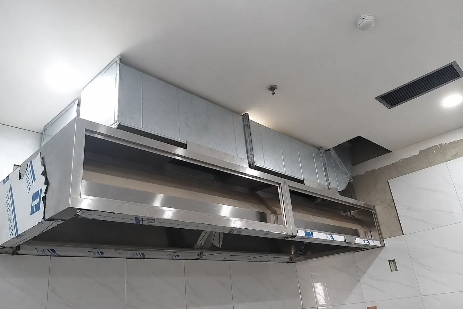 Lắp đặt lò nướng và bàn inox trong khu bếp đang thi công