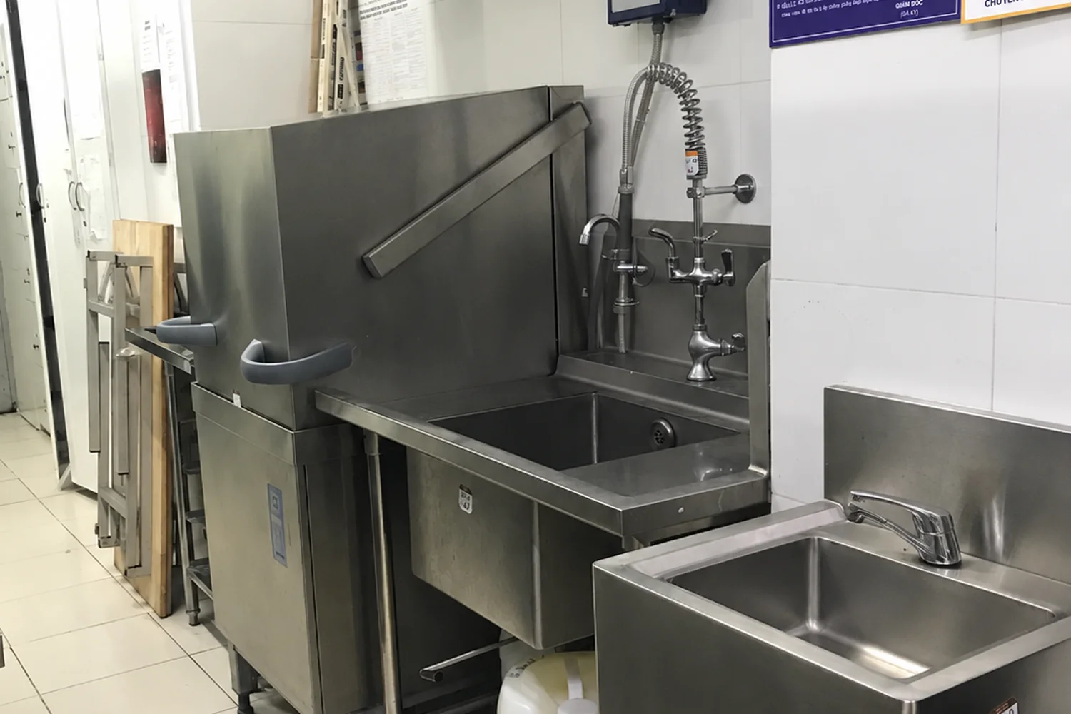 Khu rửa chén với bồn rửa và bảng an toàn PCCC